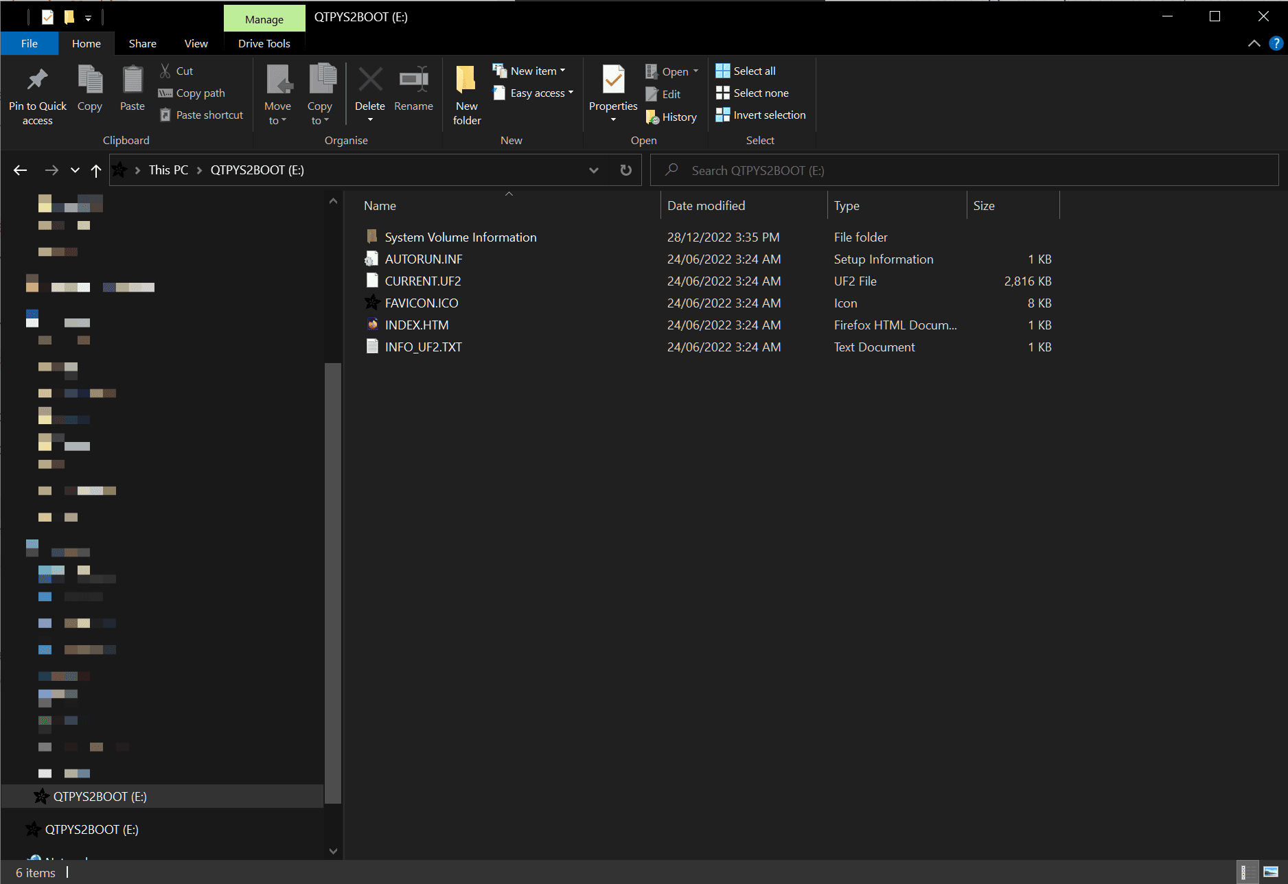 Mounted E: drive containing the following 5 files: AUTORUN.INF, CURRENT.UF2, FAVICON.ICO showing the Adafruit logo, INDEX.HTML and INFO_UF2.TXT